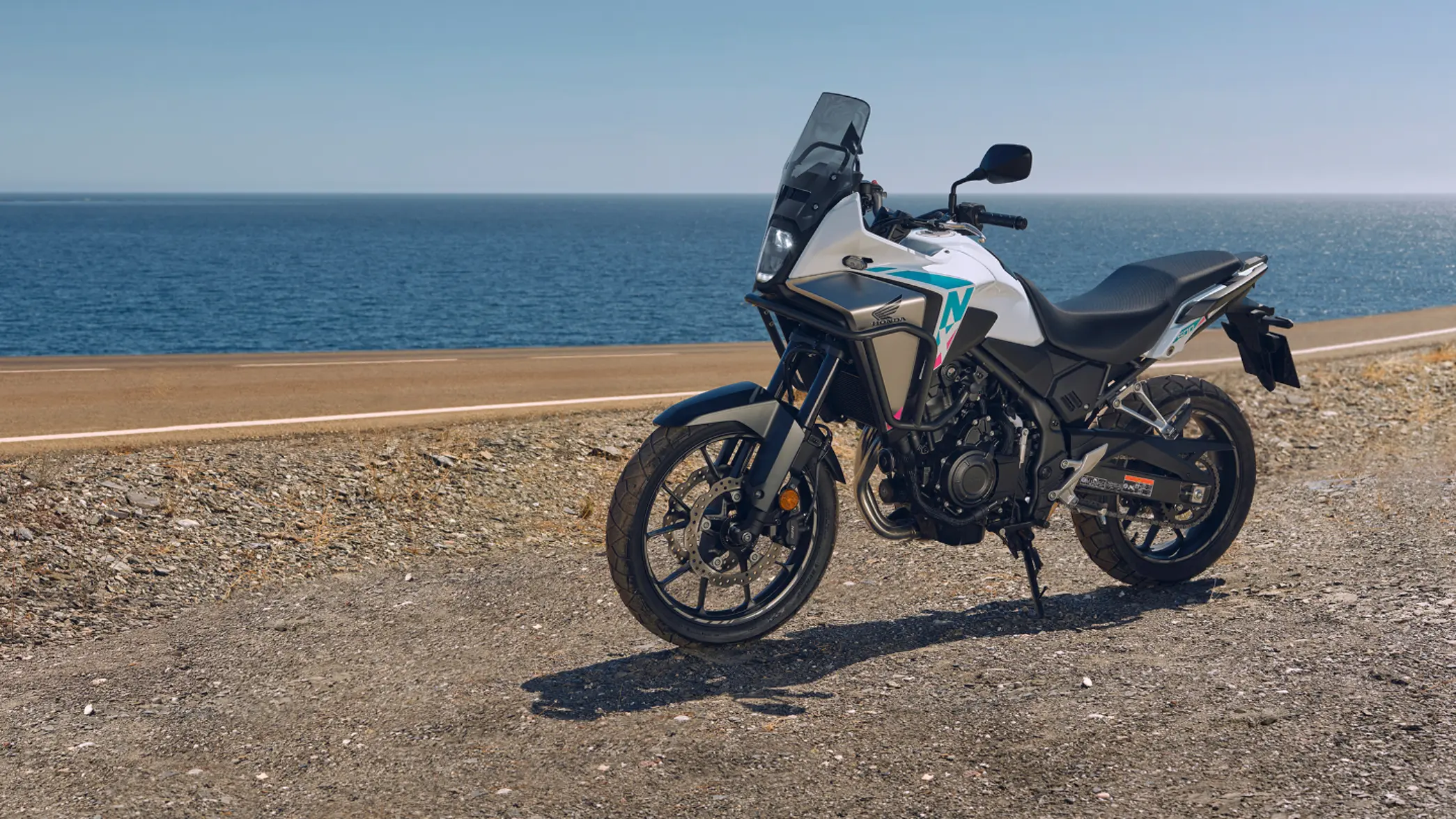 Honda NX500 – oldalról készült felvétel terepen, vízparti környezetben